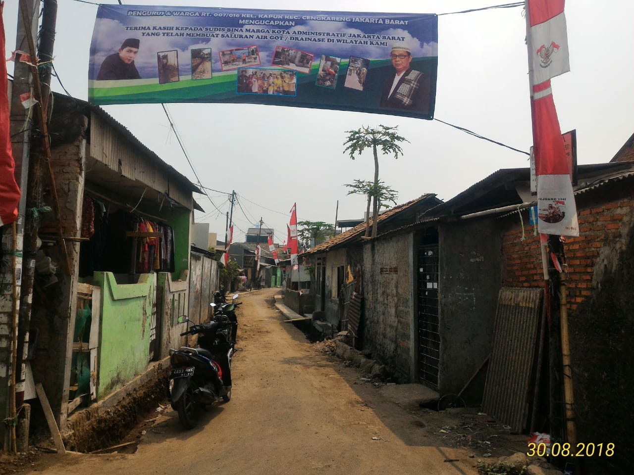 Spanduk ucapan terima kasih warga dan pengurus RT 07/16 Kapuk atas pembangunan Saluran Lingkungan di Jalan H Tabar.