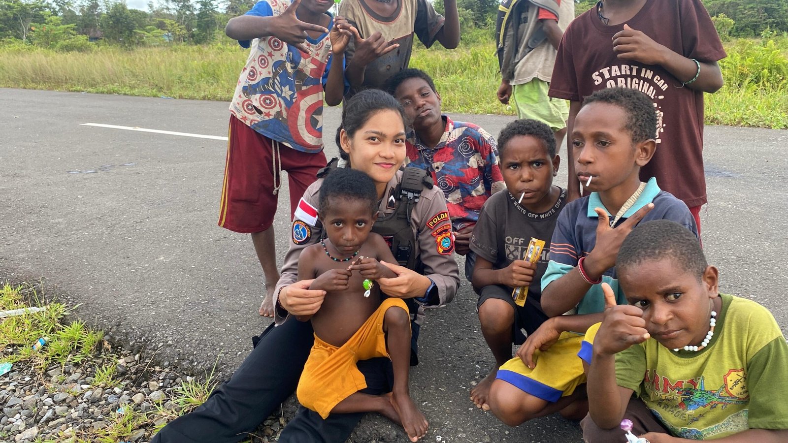 Polwan Satgas Damai Cartenz berbagi kebersamaan bersama anak-anak setempat.