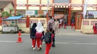 Aiptu Eman Subagja dari Polsek Cikijing membantu anak sekolah menyeberang saat Gatur Lalin di depan SDN Sukamukti II.